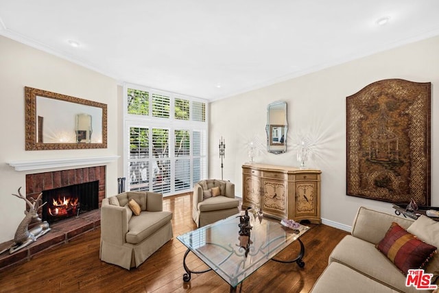 living room with hardwood / wood-style flooring, ornamental molding, and a fireplace