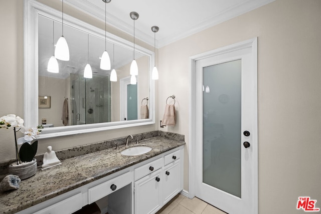 bathroom featuring tile patterned flooring, vanity, an enclosed shower, and ornamental molding