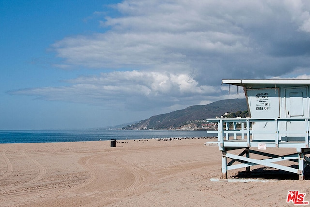 property view of water featuring a mountain view and a beach view