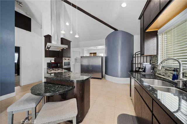 kitchen featuring dark stone countertops, sink, dark brown cabinetry, and stainless steel appliances