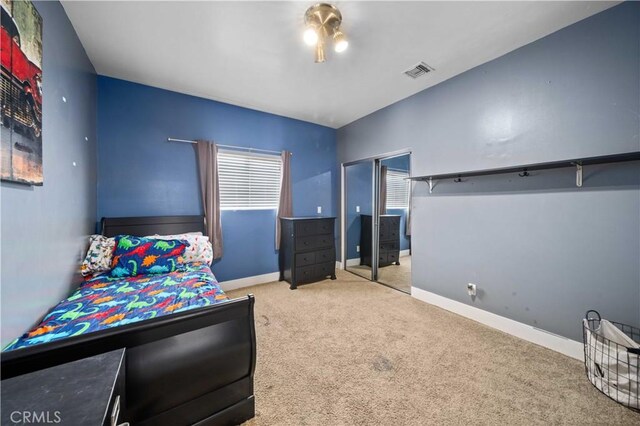 bedroom with light carpet and a closet