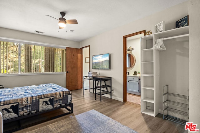 bedroom featuring hardwood / wood-style flooring, ceiling fan, and ensuite bathroom