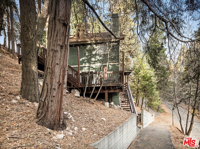 rear view of house featuring a wooden deck