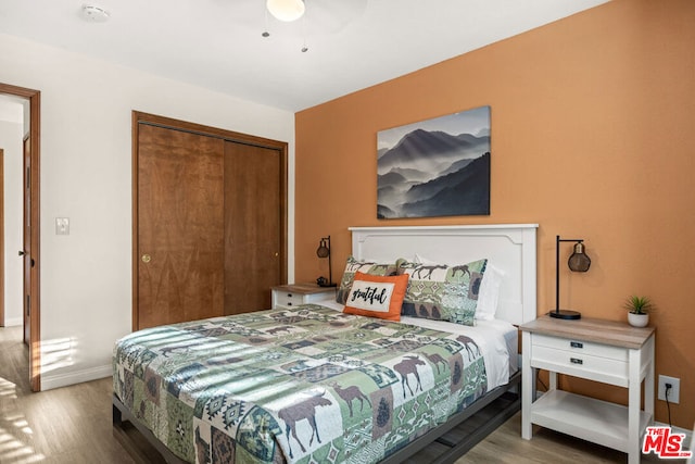 bedroom with a closet, light hardwood / wood-style floors, and ceiling fan