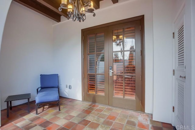 interior space featuring beam ceiling, french doors, and an inviting chandelier