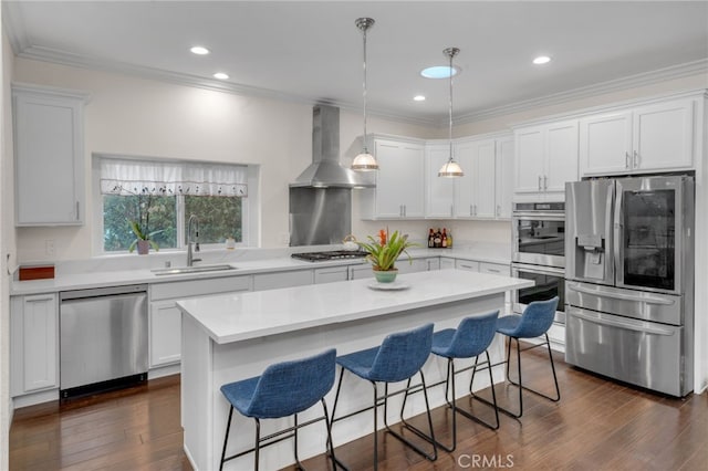 kitchen featuring stainless steel appliances, white cabinetry, wall chimney exhaust hood, and sink