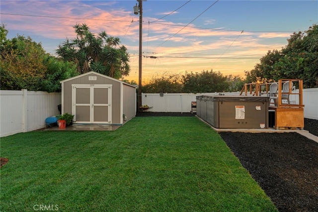 yard at dusk featuring a storage shed