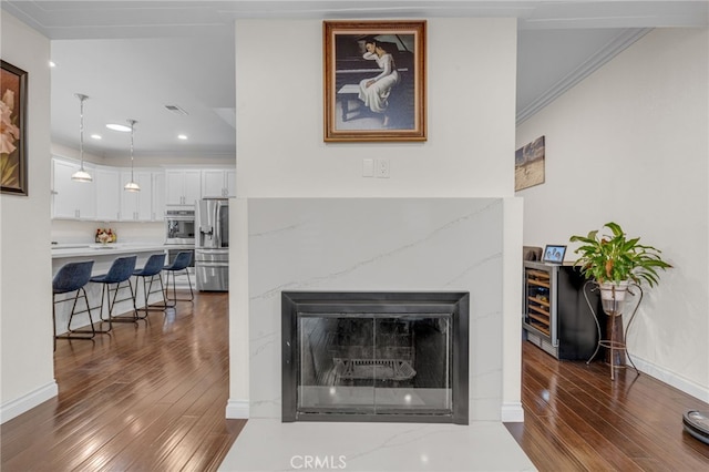 room details with hardwood / wood-style floors, stainless steel refrigerator with ice dispenser, and ornamental molding