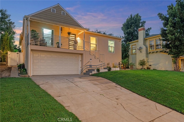 view of front of property featuring a lawn and a balcony