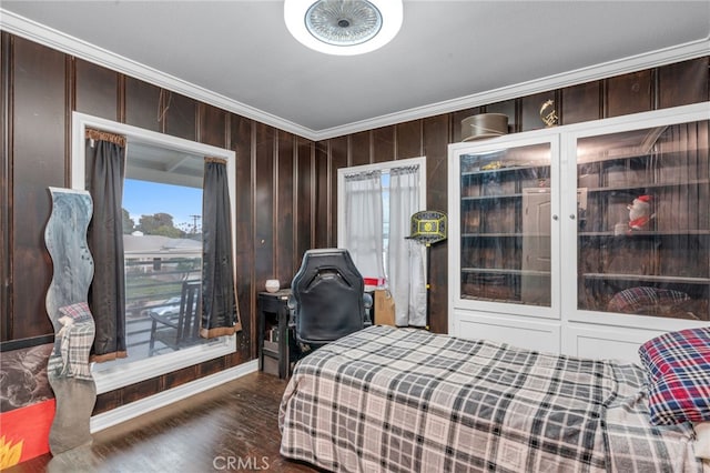 bedroom featuring wood walls, crown molding, and dark wood-type flooring