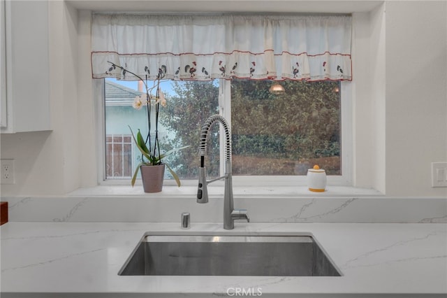 details featuring light stone counters and sink