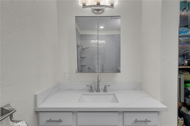 bathroom with vanity and tiled shower