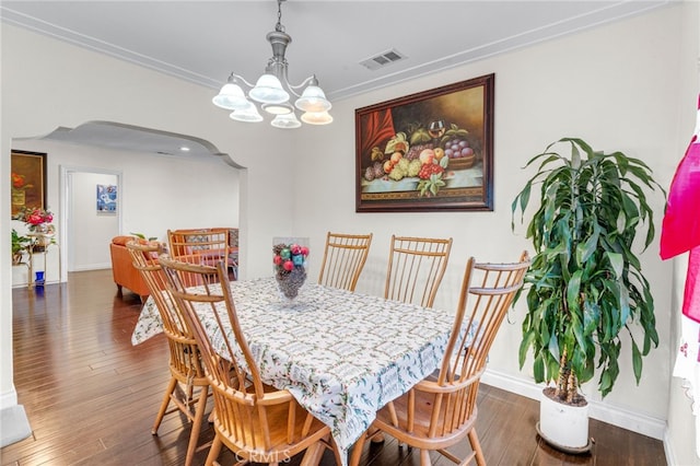 dining space with dark hardwood / wood-style flooring, a chandelier, and ornamental molding