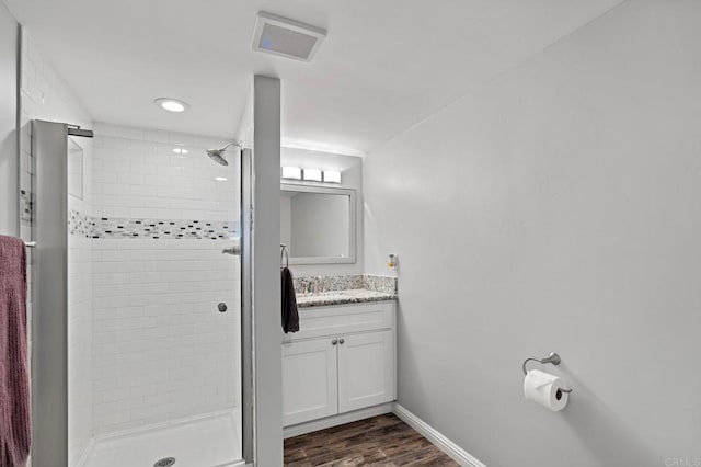 bathroom featuring tiled shower, vanity, and hardwood / wood-style flooring