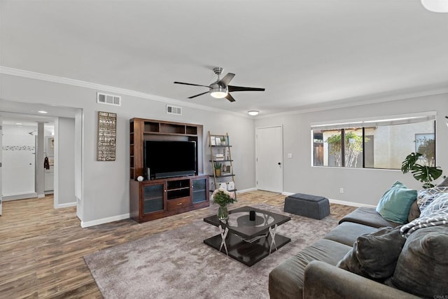 living room with wood-type flooring, ceiling fan, and crown molding