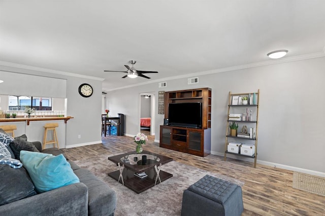 living room featuring ceiling fan, hardwood / wood-style floors, and ornamental molding