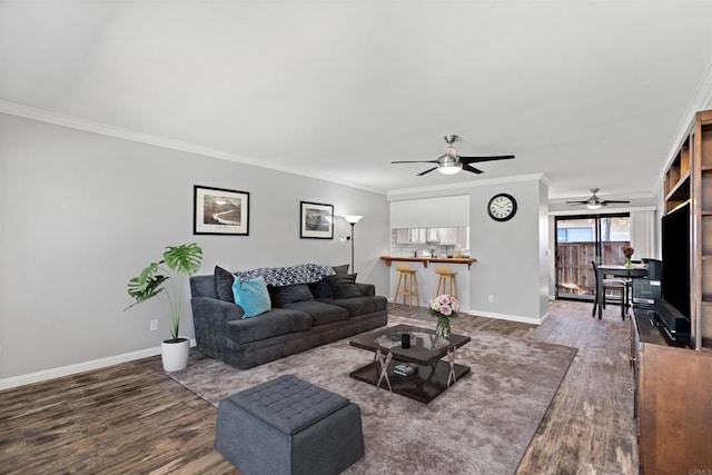 living room featuring ceiling fan, ornamental molding, and hardwood / wood-style flooring