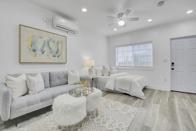 bedroom featuring a wall mounted AC, ceiling fan, and light hardwood / wood-style floors