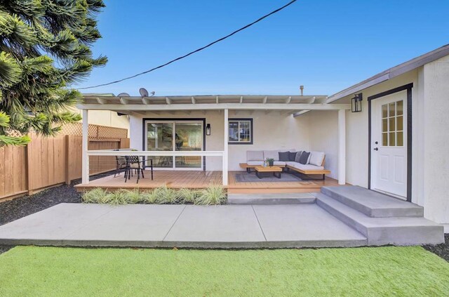 back of property featuring a deck and an outdoor hangout area