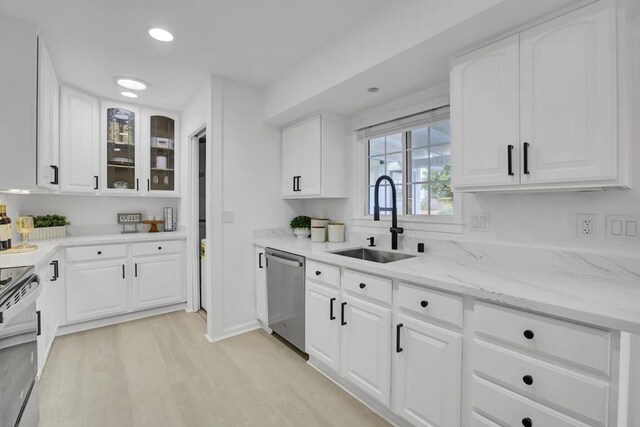 kitchen featuring electric stove, light wood-type flooring, sink, white cabinetry, and stainless steel dishwasher