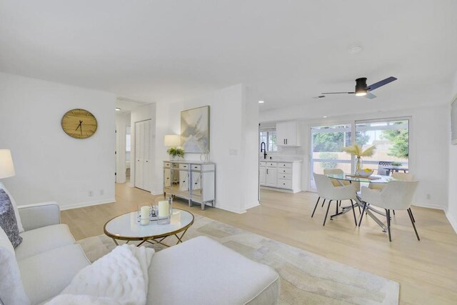 living room featuring light wood-type flooring and ceiling fan