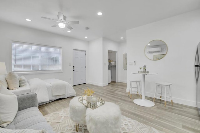 bedroom featuring ceiling fan, light hardwood / wood-style floors, and an AC wall unit