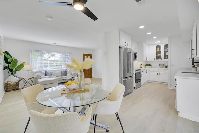 dining room with ceiling fan and light hardwood / wood-style floors