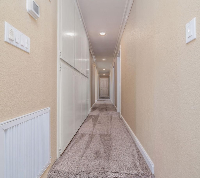 corridor featuring light colored carpet and ornamental molding