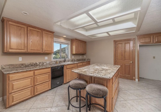 kitchen with light stone counters, a center island, a textured ceiling, and black dishwasher