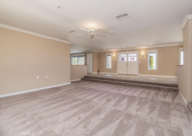 unfurnished living room with carpet, ceiling fan, crown molding, and a wealth of natural light