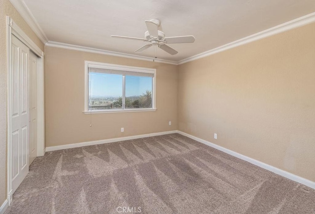 unfurnished bedroom featuring carpet flooring, crown molding, and ceiling fan