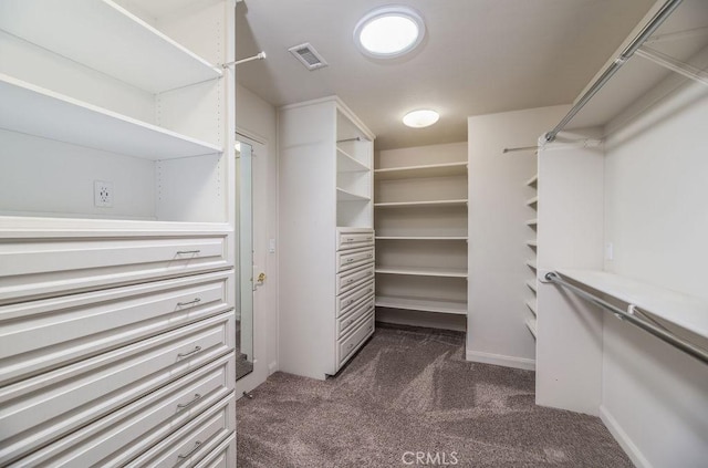 walk in closet featuring dark carpet