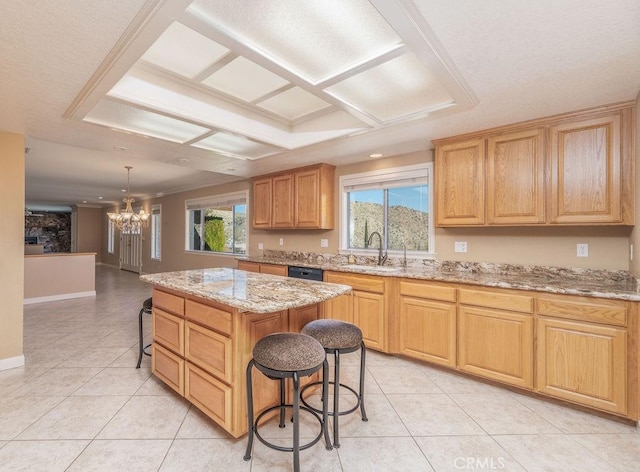 kitchen with sink, a chandelier, decorative light fixtures, a kitchen bar, and a kitchen island