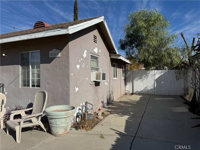 view of side of property featuring cooling unit and a patio area