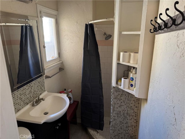 bathroom with a shower with shower curtain, vanity, and tile walls