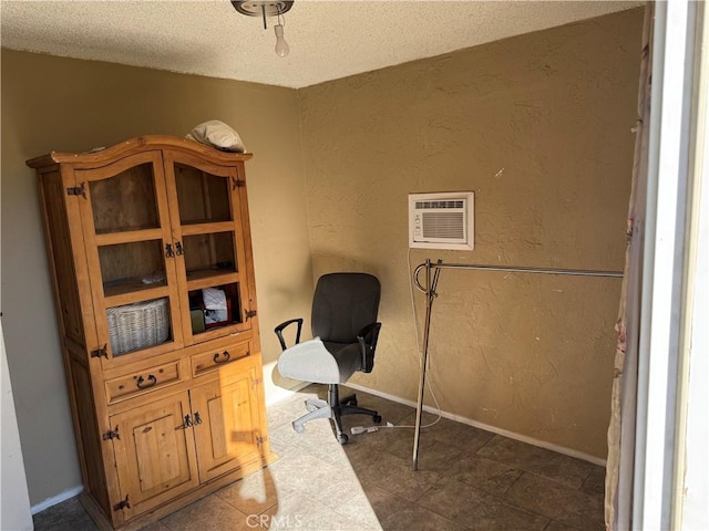 tiled home office with an AC wall unit and a textured ceiling