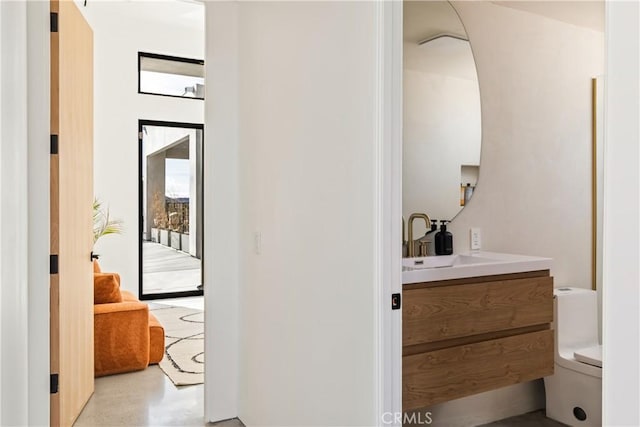 bathroom featuring concrete flooring, vanity, and toilet