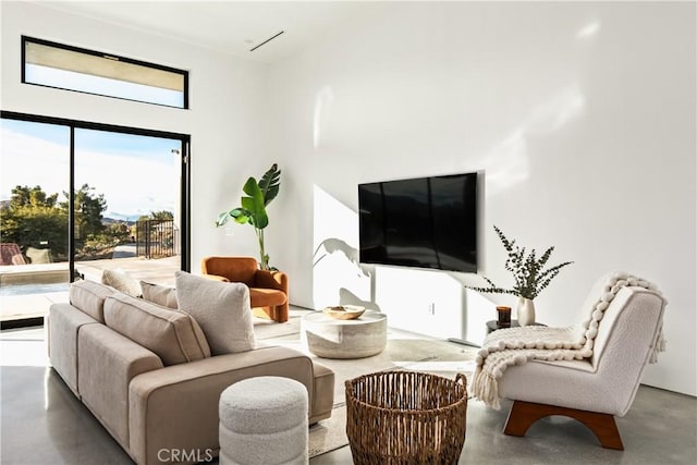 living room featuring concrete floors and a high ceiling