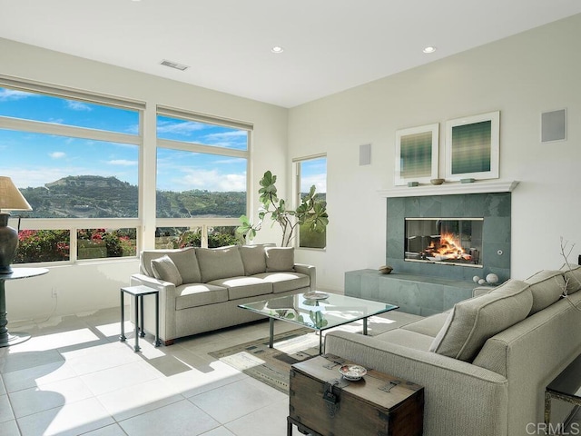 living room featuring light tile patterned flooring, a mountain view, and a tile fireplace