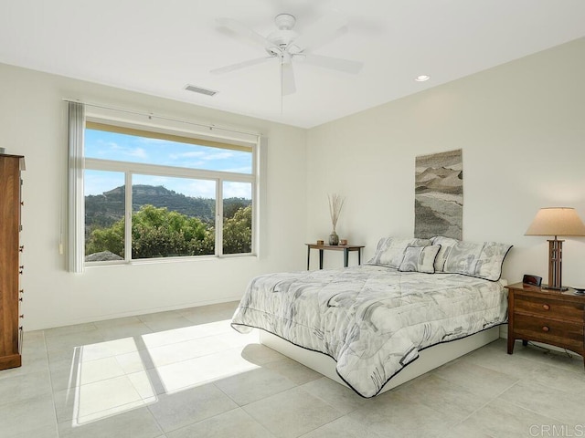 bedroom featuring a ceiling fan, visible vents, and light tile patterned floors