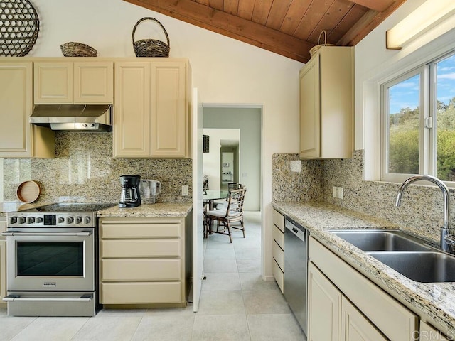 kitchen with lofted ceiling with beams, light tile patterned flooring, a sink, appliances with stainless steel finishes, and range hood