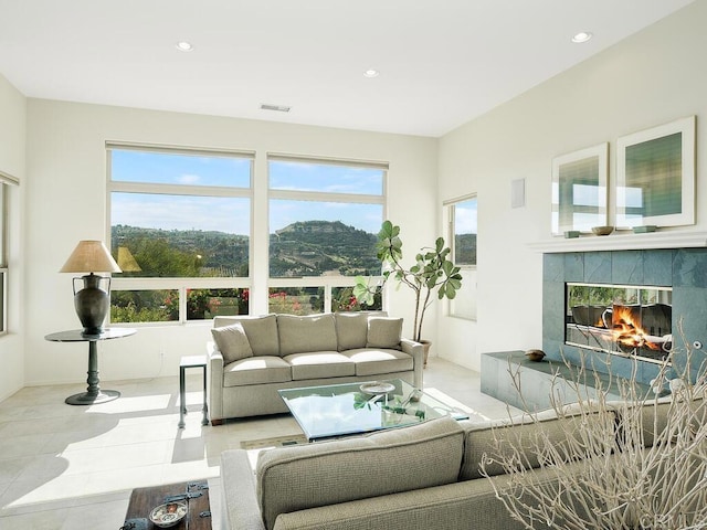 living room with a tile fireplace, visible vents, tile patterned floors, and recessed lighting