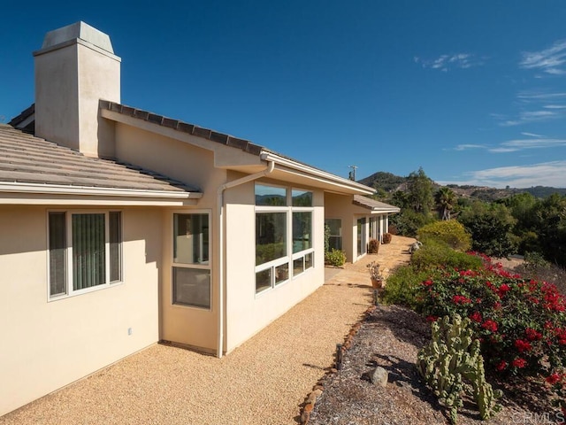 exterior space featuring a chimney and stucco siding