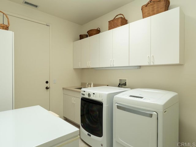 laundry area with cabinet space, visible vents, and washer and dryer