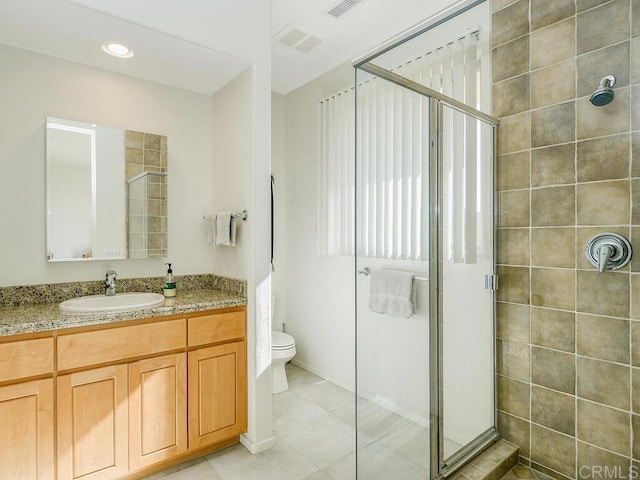 bathroom featuring toilet, tile patterned flooring, a shower stall, and vanity