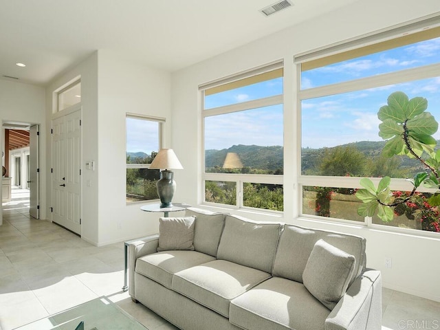 interior space featuring visible vents, baseboards, light tile patterned flooring, and a mountain view