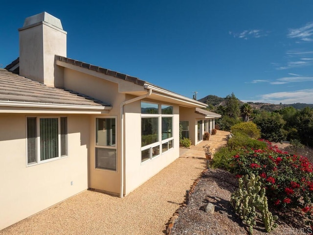 31340 Cottontail Ln, Bonsall, CA 92003 - rear view of property with a chimney, stucco siding, and a mountain view