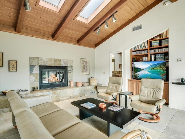 31340 Cottontail Ln, Bonsall, CA 92003 - tiled living area featuring wood ceiling, a skylight, beamed ceiling, a high end fireplace, and high vaulted ceiling