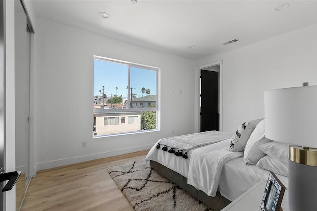 bedroom with light wood-type flooring and a closet