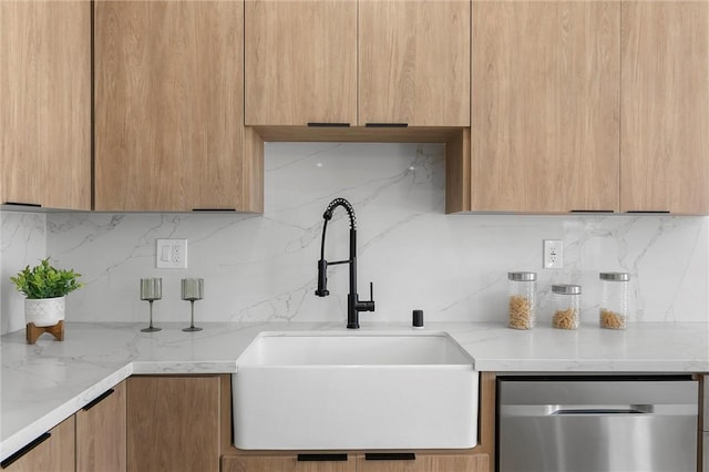 kitchen featuring sink, backsplash, dishwasher, and light stone countertops